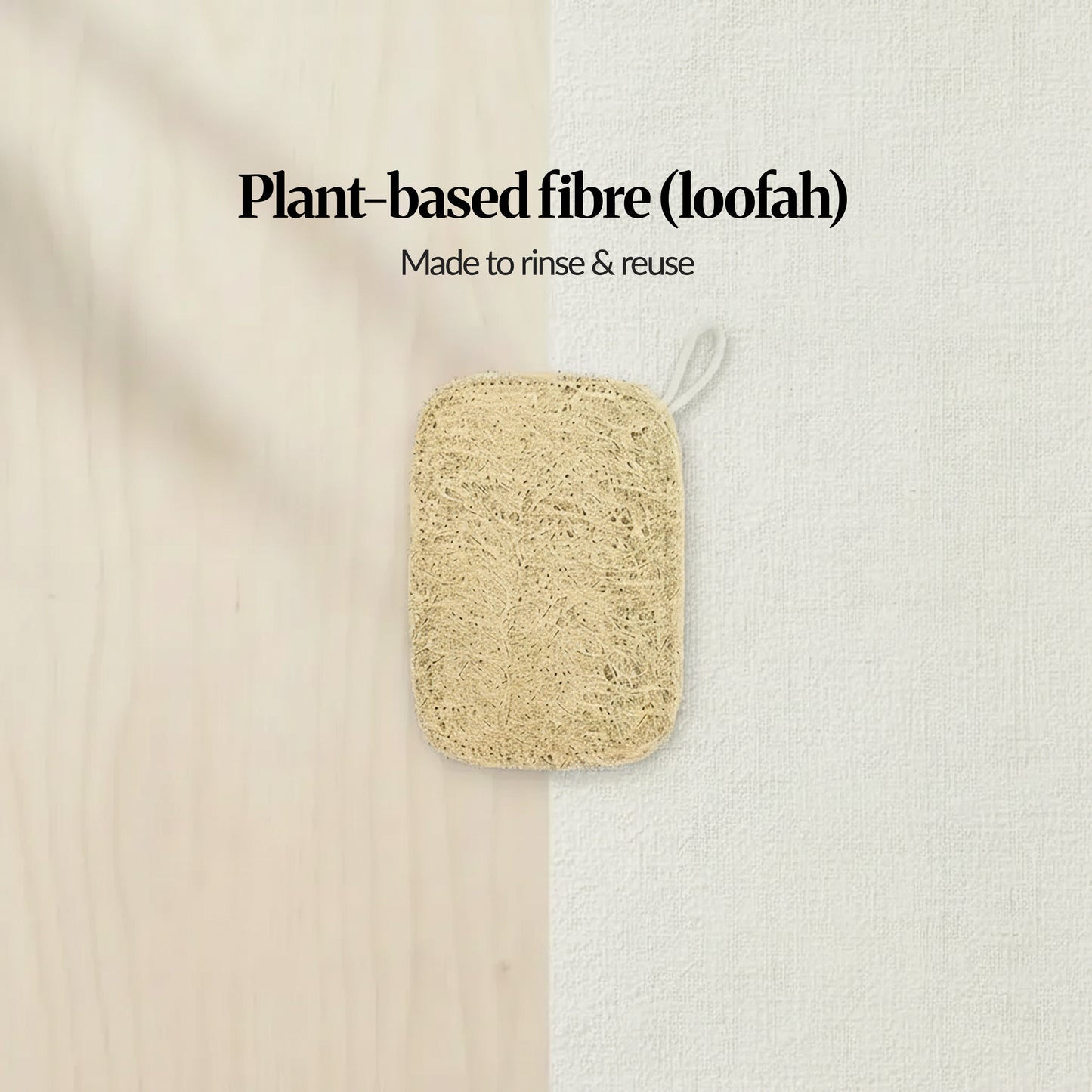 Natural loofah sponge (plant-based fibre) with hanging loop, shown on a light wood-and-linen background with text “Made to rinse & reuse.”