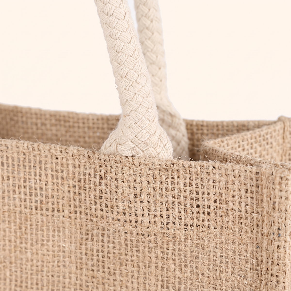 Close-up of the natural woven texture where the braided rope handle meets the bag