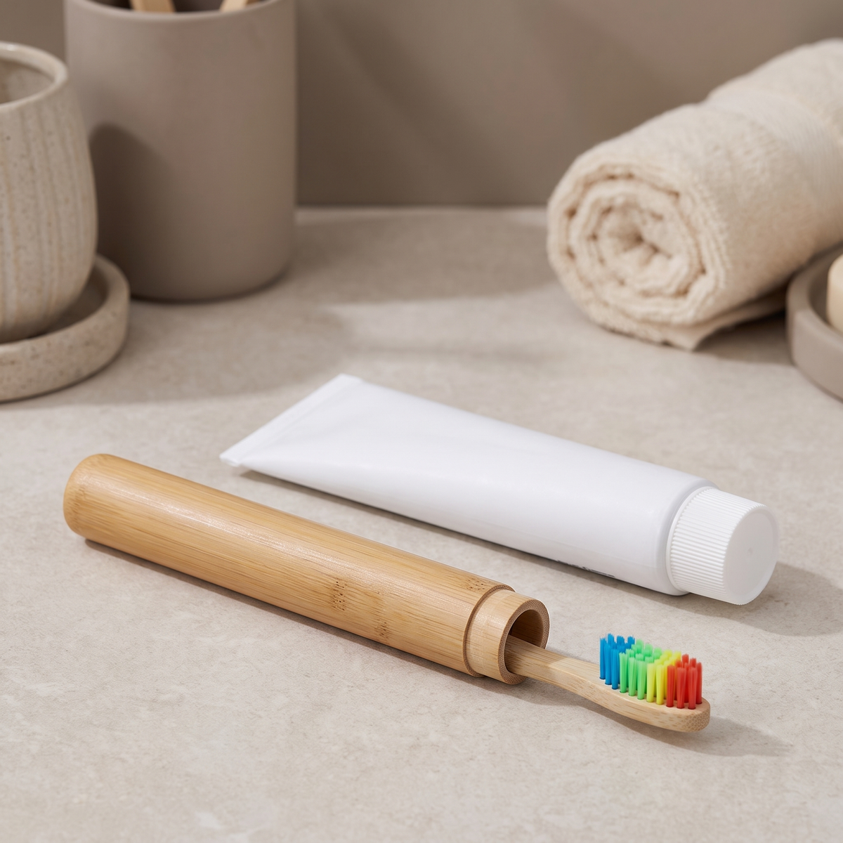 Bamboo case with a toothbrush beside a tube of toothpaste on a bathroom counter