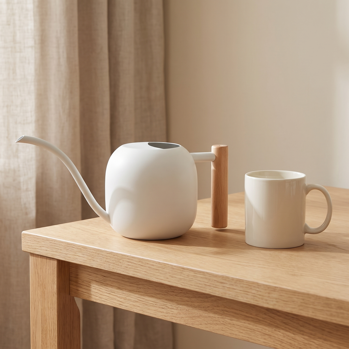 White watering can beside a cream mug on a wooden table for size