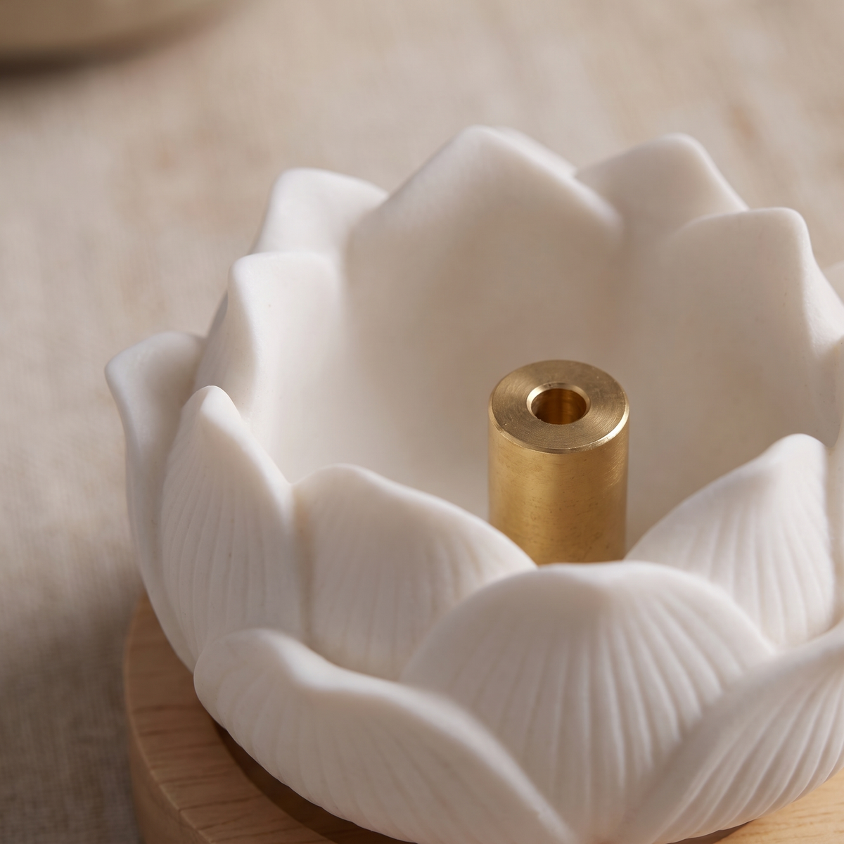 Close-up of the gold-tone stick holder inside the white ceramic lotus petals