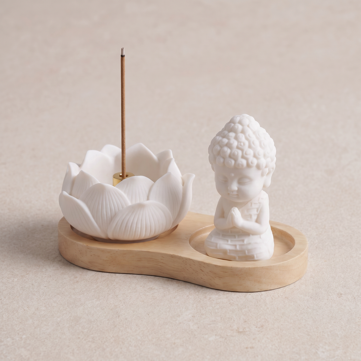 Ceramic lotus with one incense stick beside the monk figure on a light wood tray