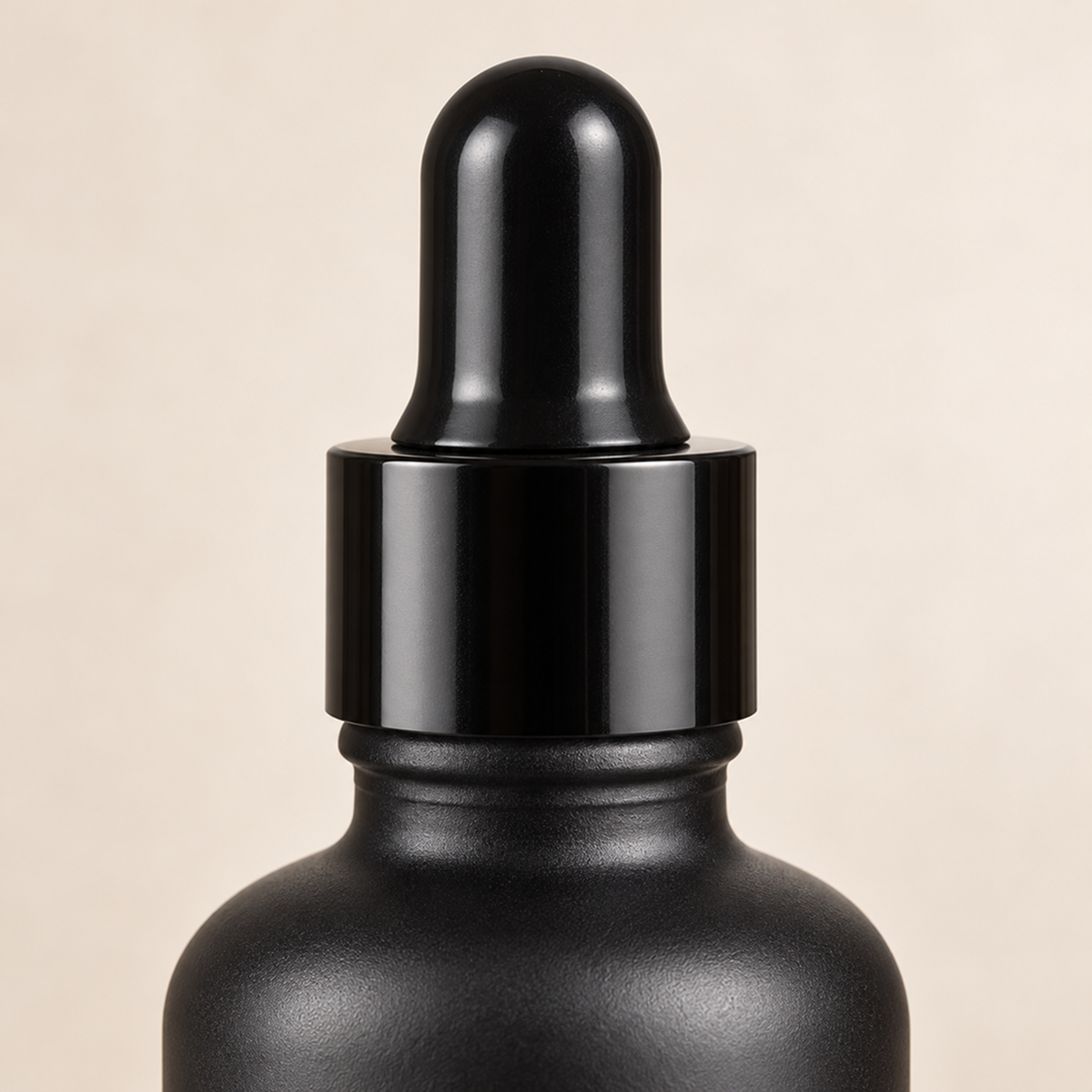Close-up of the black bulb and glossy collar on a matt frosted bottle