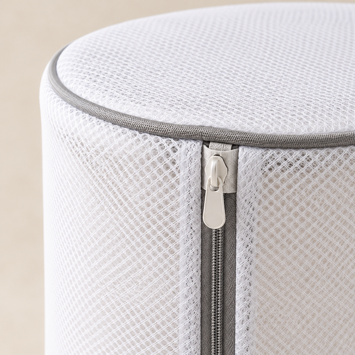Close-up of the white mesh, grey edge binding and zip pull at the top