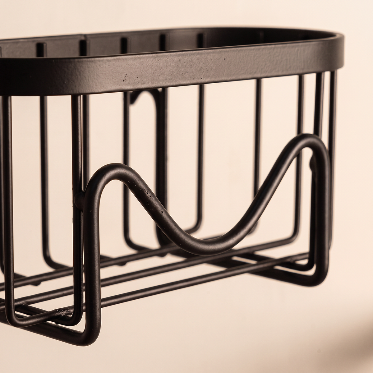 Close-up of the black wire basket and wave-shaped sponge rack