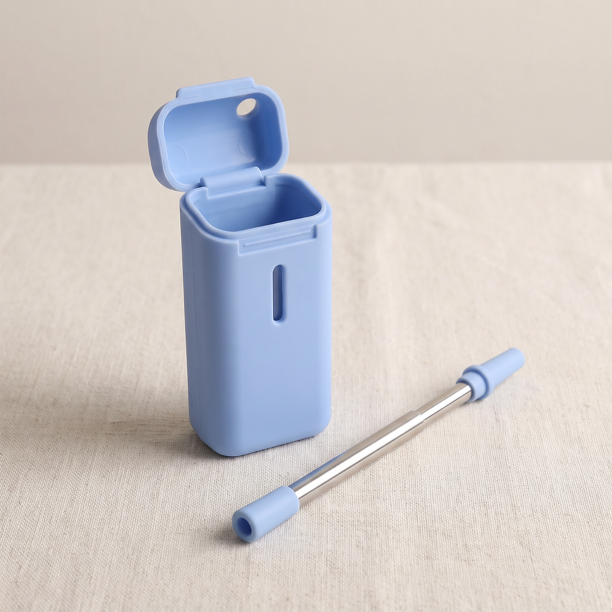 The blue case open on linen, with the straw lying beside it