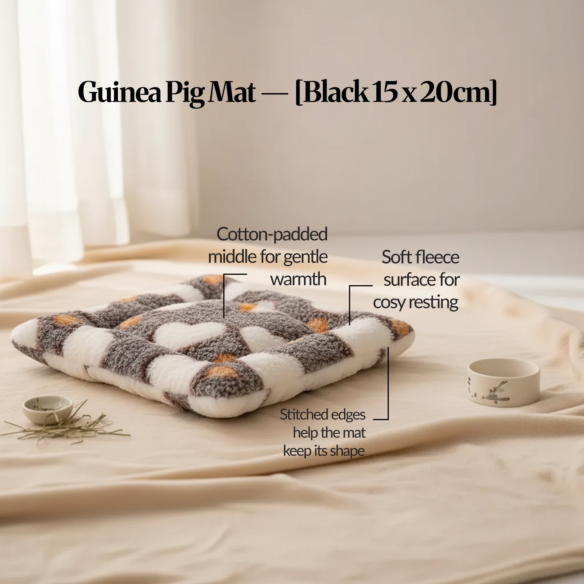 Black guinea pig bed mat (15×20cm) soft fleece mat with cotton padding and stitched edging, photographed on a warm neutral surface with feature callouts