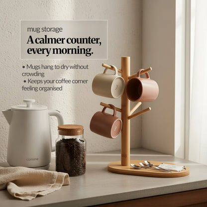Bamboo mug storage stand on a kitchen counter holding mugs, beside a kettle and coffee jar; shows an organised coffee corner with mugs hanging to dry.