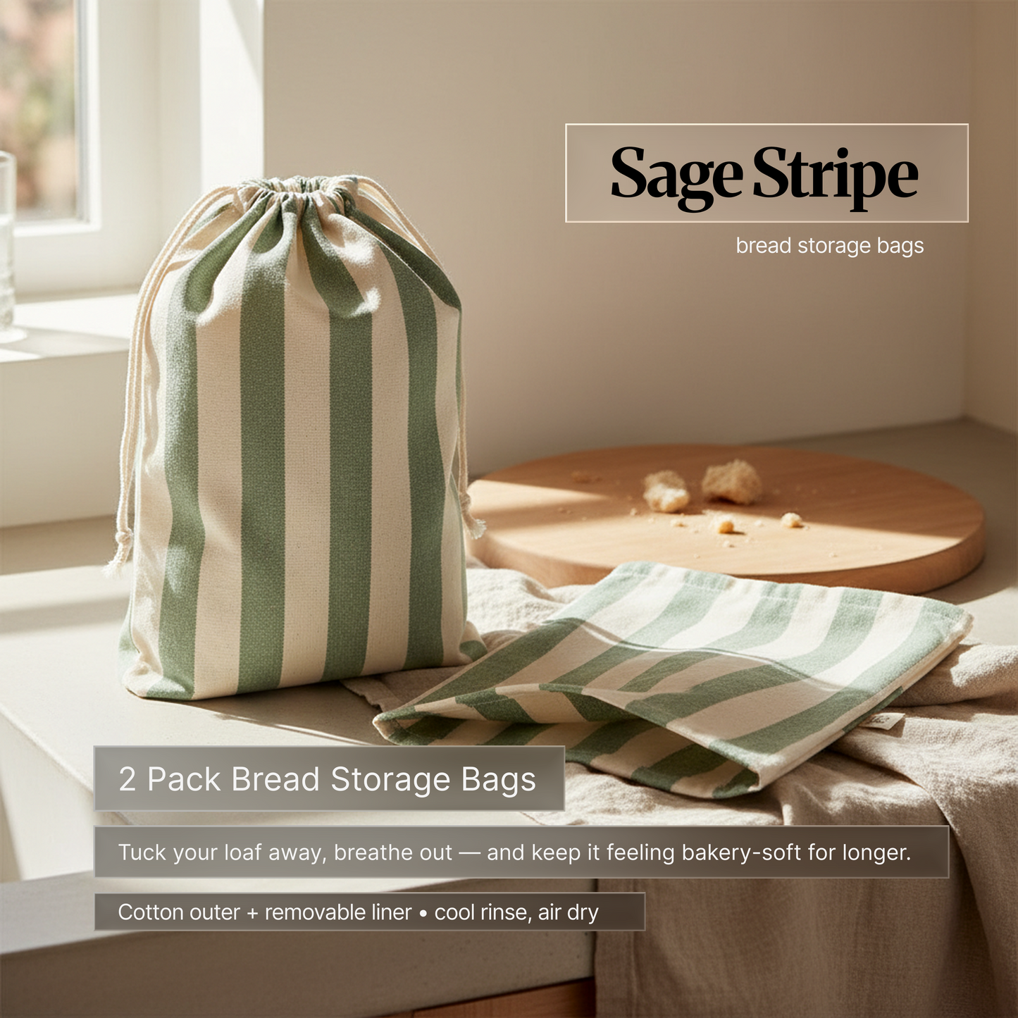 Sage green striped cotton bread storage bag set (2-pack) on a kitchen counter by a window; drawstring bag and matching liner designed to keep bread bakery-soft longer.