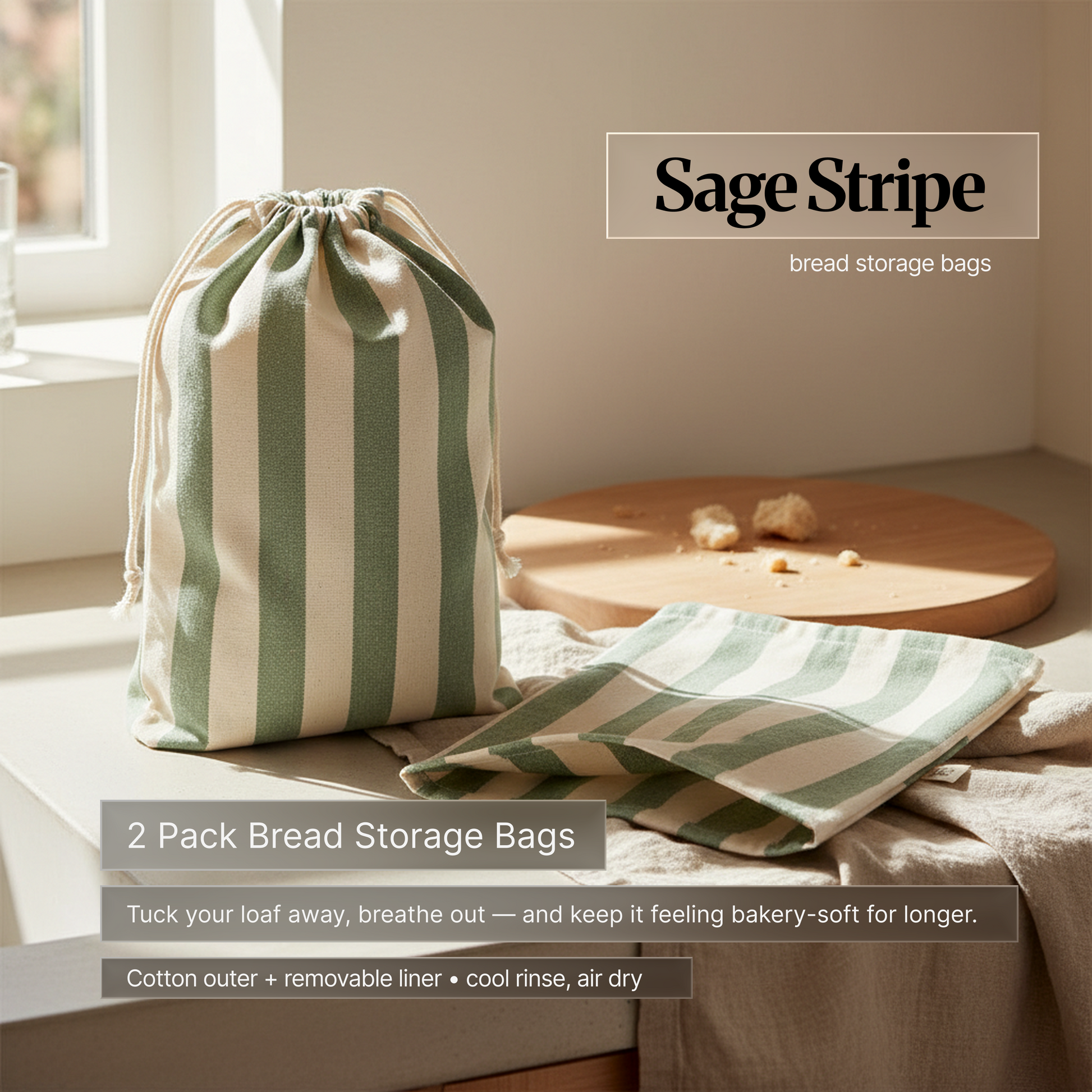 Sage green striped cotton bread storage bag set (2-pack) on a kitchen counter by a window; drawstring bag and matching liner designed to keep bread bakery-soft longer.