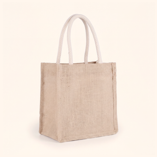 Small natural jute tote bag with braided rope handles on a soft cream background