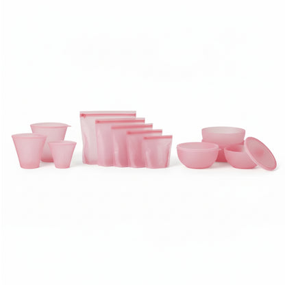 PR069 pink silicone food storage set laid out on a white background — reusable cups plus zip-top silicone bags and lidded bowls (complete set).