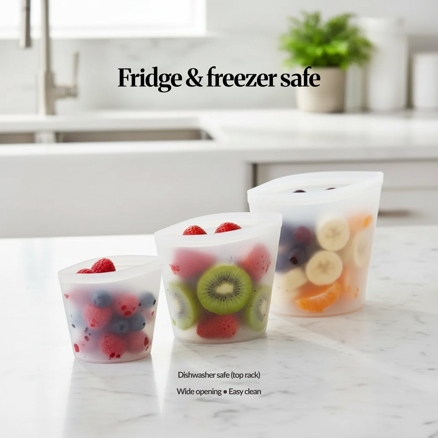 Bags set (2pcs) — transparent — Two clear reusable silicone food storage bags on a kitchen counter, filled with mixed fruit and snacks to show everyday storage and reuse.
