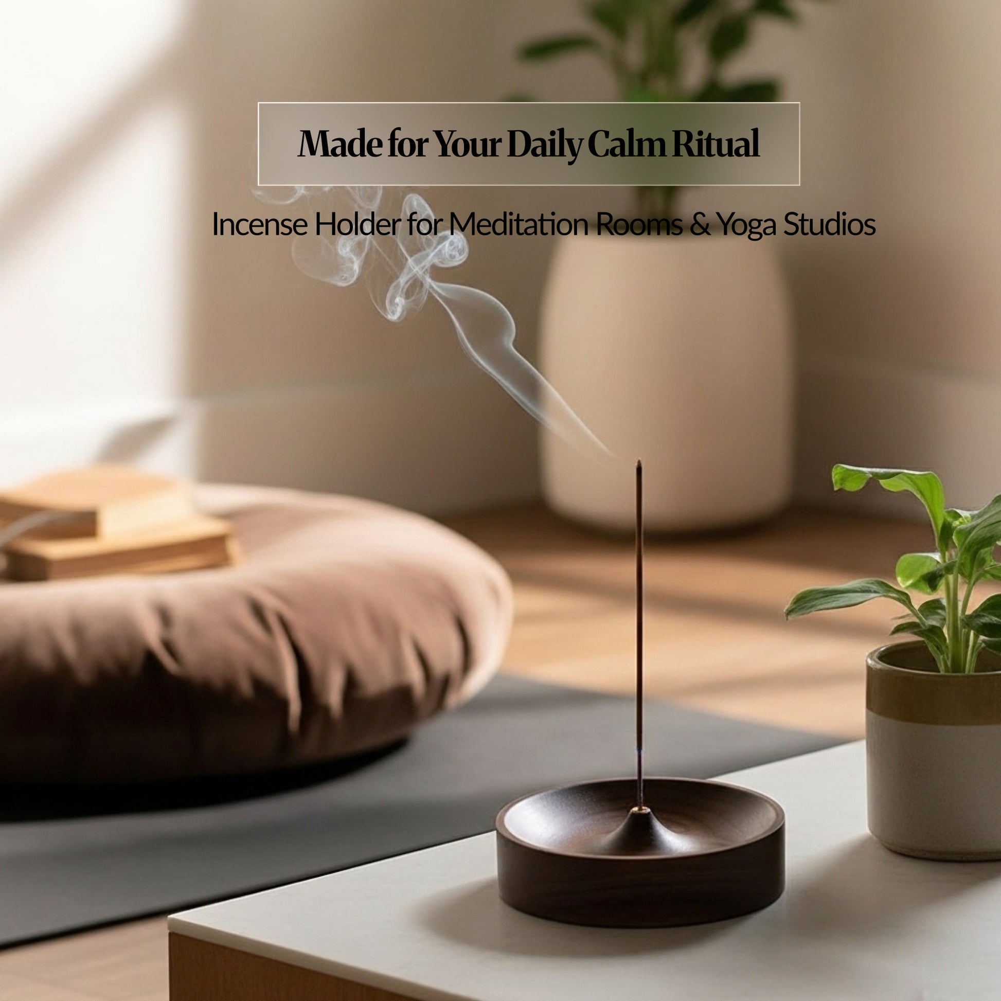 Incense stick burning in a dark wooden ash-catching bowl on a low table beside a plant and floor cushion, with smoke rising in a calm meditation space.