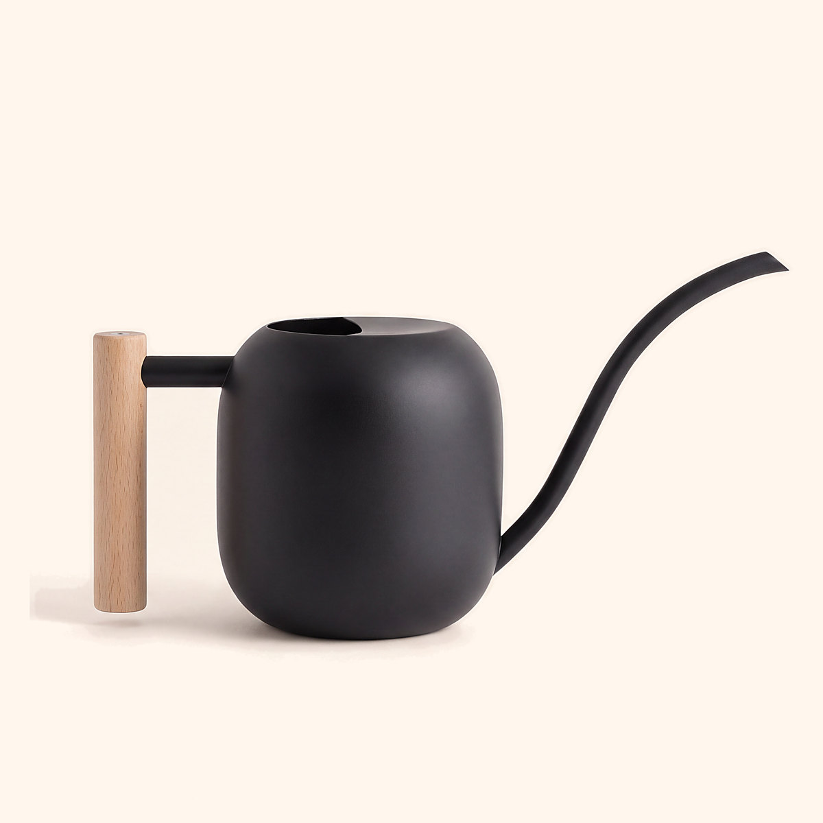 Matte black watering can with a gooseneck spout and upright wooden handle, on cream